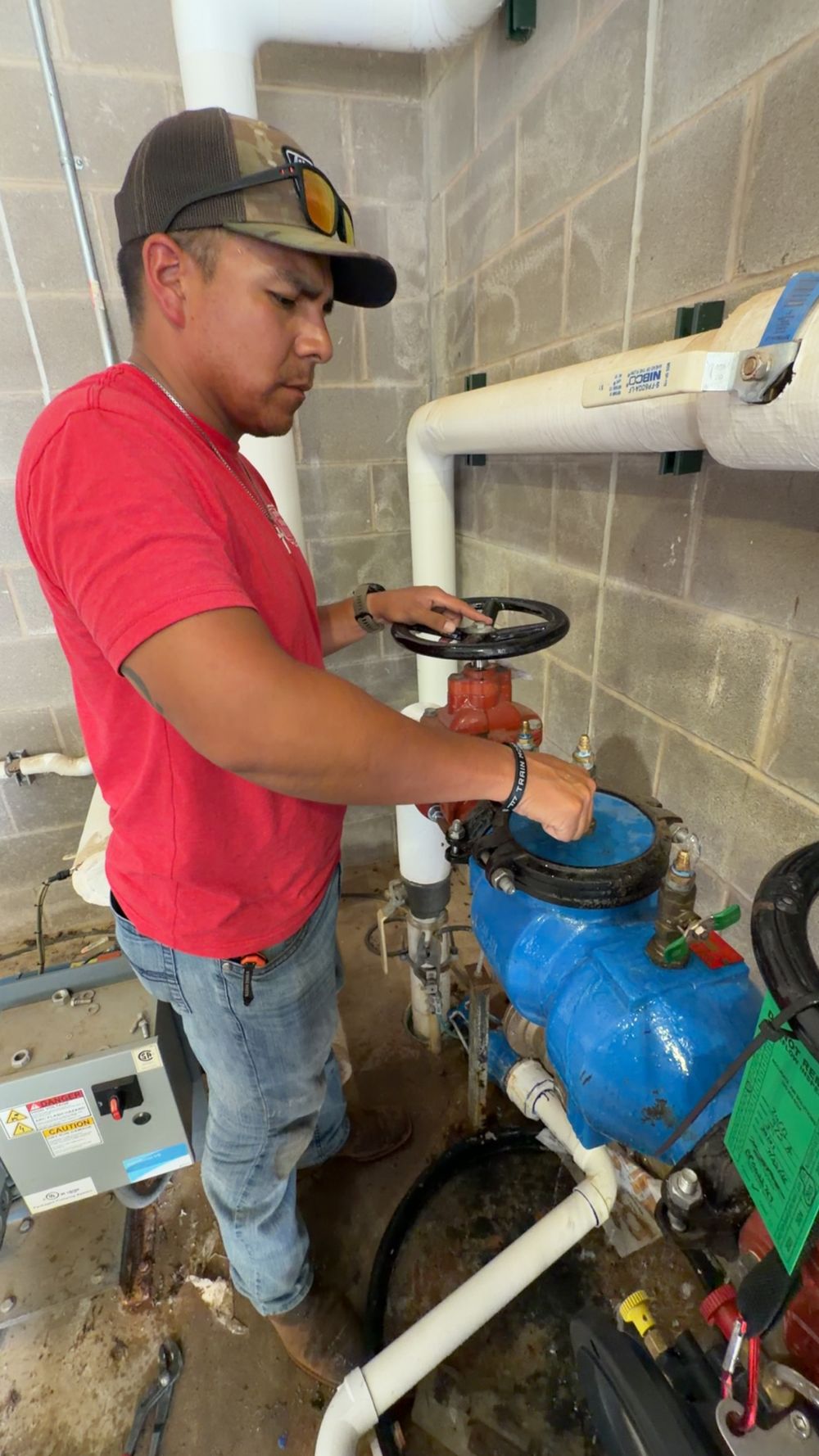 Double R Plumbing technician performing a certified backflow test